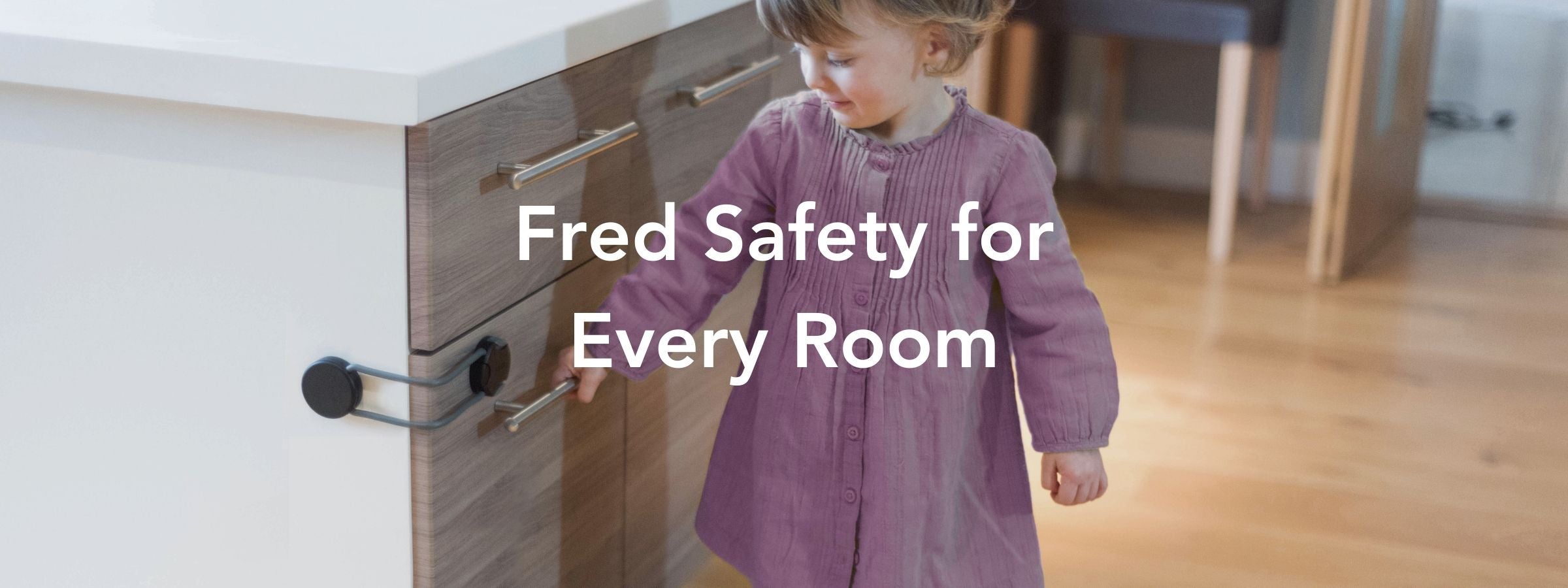 A young child in a pink dress stands near a kitchen cabinet secured with a safety lock. White text over the image reads, Fred Safety for Every Room.