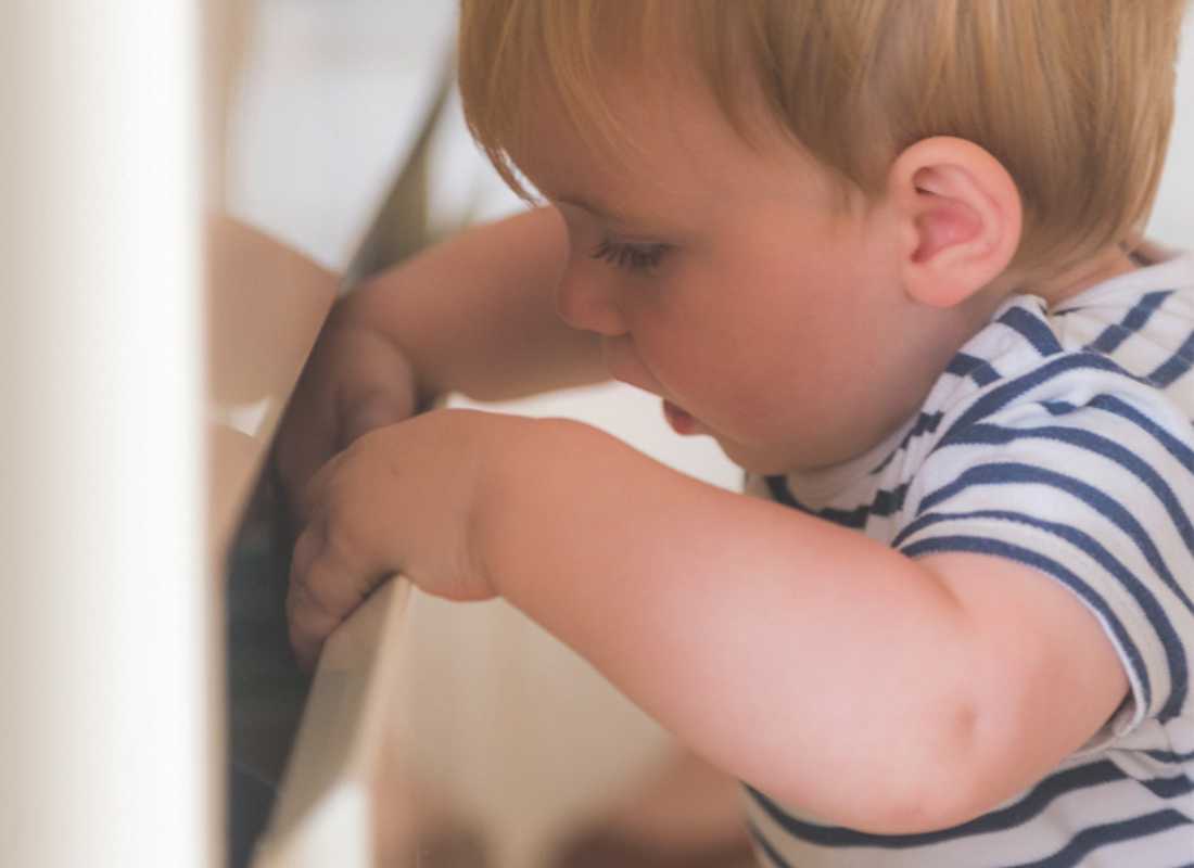 Toddler looks into a Cabinet