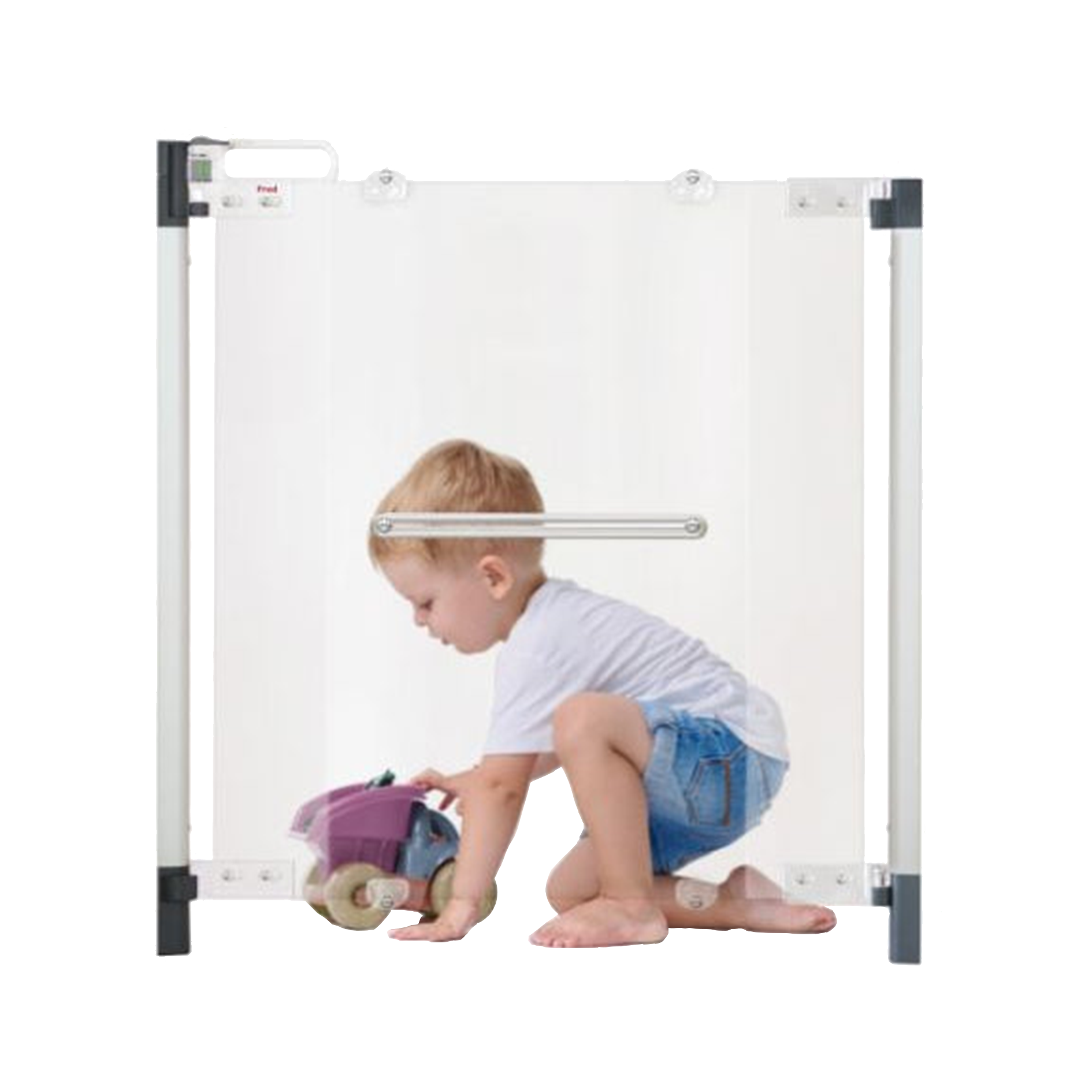 A young child in a white t-shirt and denim shorts kneels on the floor playing with a toy car behind a transparent safety gate.