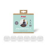 A package labeled “Fred plug socket cover x6” with six white baby safety plugs displayed in front. The packaging features a photo of a child and key benefits like “Child-proof outlet” and “Easy fitting.”.
