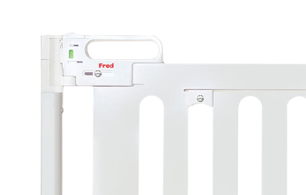 A close-up of a white screw fit stair gate with a white handle and a red 'Fred' logo.